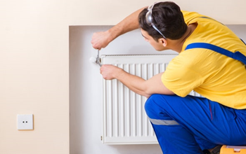 A handyman fixes a vent in a house