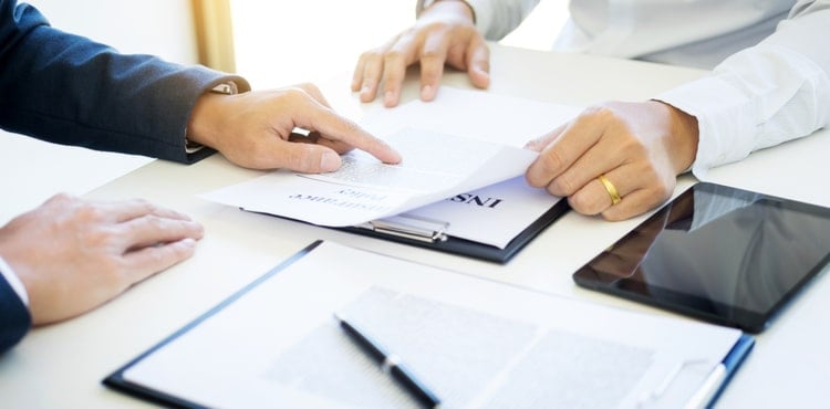 Two people reading a certificate of insurance form