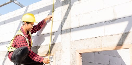 General contractor measuring a structure for a project.