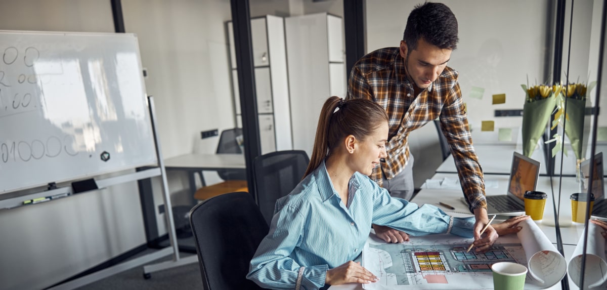 Two small business professionals reviewing paperwork for a specific project Two small business professionals reviewing paperwork for a specific project