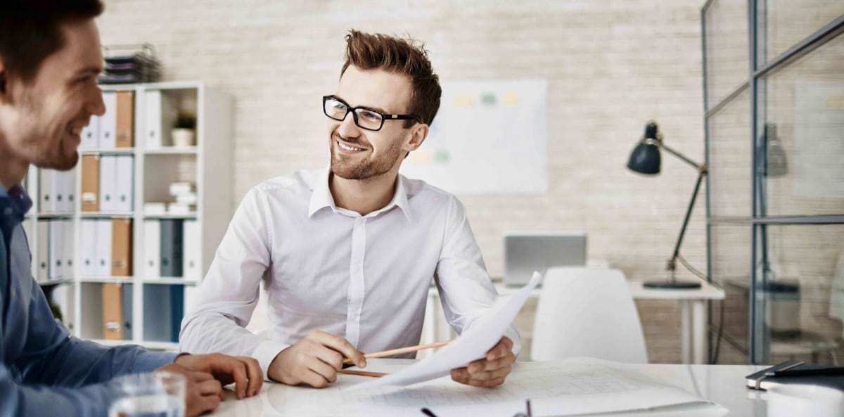 Small business owner reviewing notes with a client. Small business owner reviewing notes with a client.
