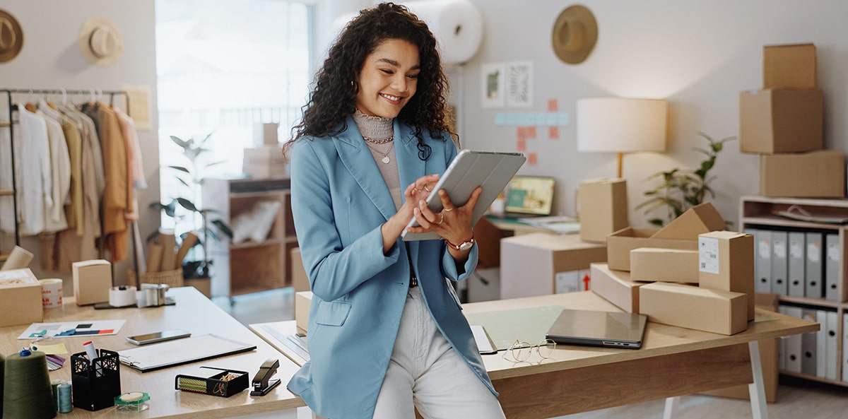 A small business owner reviewing her company information on a tablet.