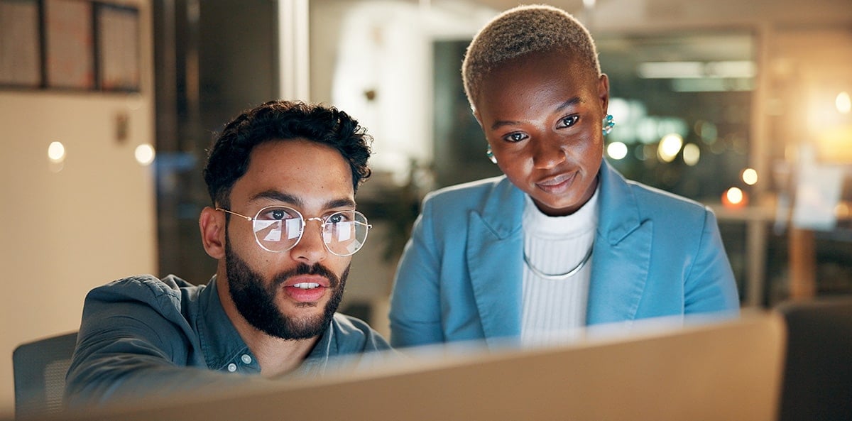 Cybersecurity experts discussing over a computer. Cybersecurity experts discussing over a computer.