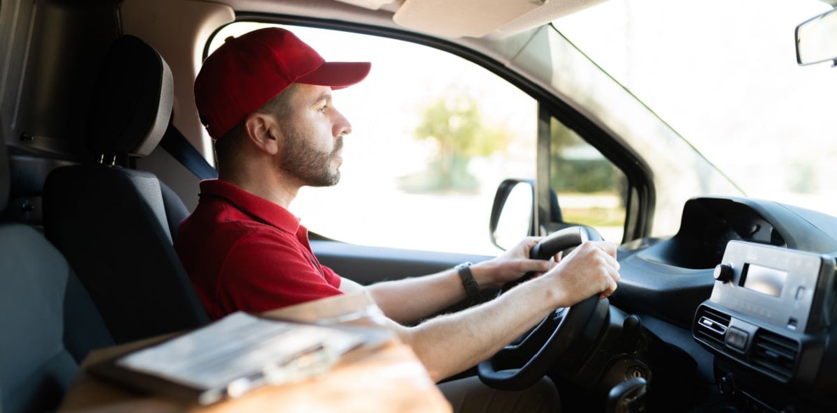 Worker driving to deliver a package. Worker driving to deliver a package.