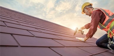 Contractor on roof making repairs.