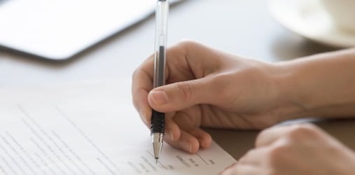 Business person signing license paperwork.
