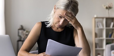 Person looking stressed reviewing a document.