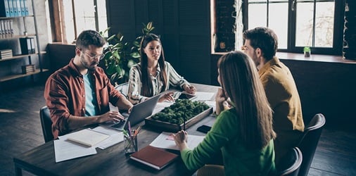 Four colleagues having a meeting around a table in a office.