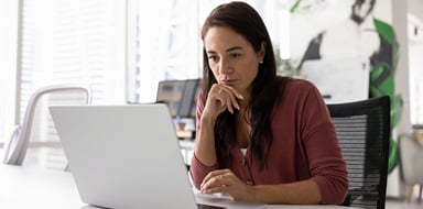 Woman working on laptop in an office.