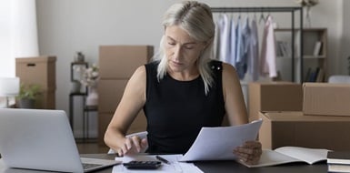 Person reviewing tax deduction documents in front of a laptop.