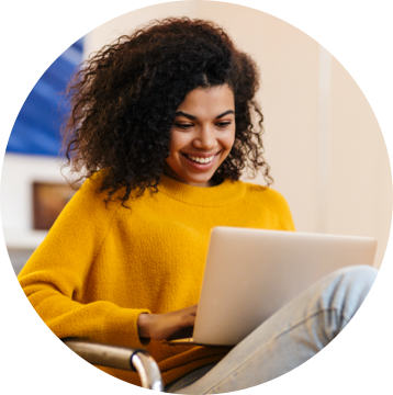 Person in a yellow shirt working on a laptop.