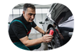 Auto shop employee detailing a car.