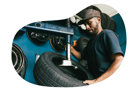 Tire shop employee working on a customer's car.