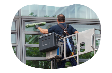 A contractor cleans the exterior of an office building.