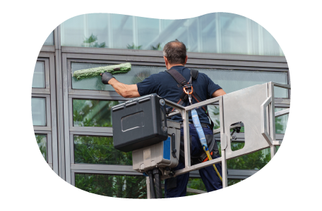 A contractor cleans the exterior of an office building. A contractor cleans the exterior of an office building.