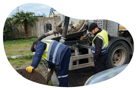 Employees cleaning out a septic tank.