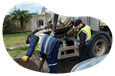 Employees cleaning out a septic tank.