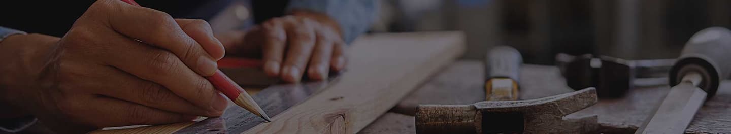 A carpenter marking a line on a board.