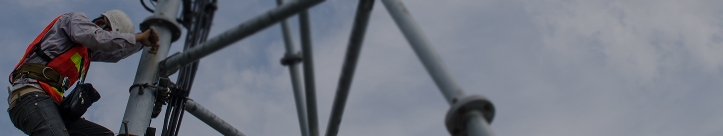 A cell tower technician climbs down after completing a job.