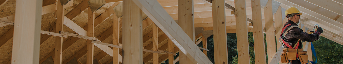 A framing contractor constructs the wooden structure of a building.