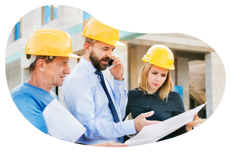 A group of framing contractors look over the blueprints to a building. A group of framing contractors look over the blueprints to a building.