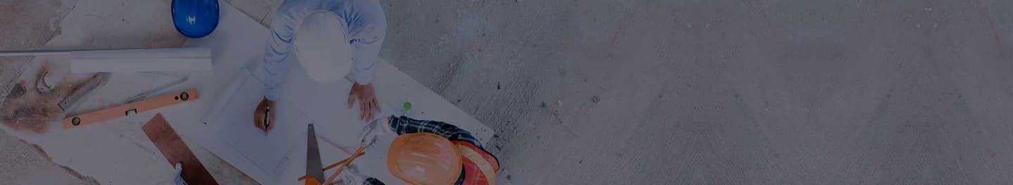 Construction employees and contractors at a table reviewing plans.