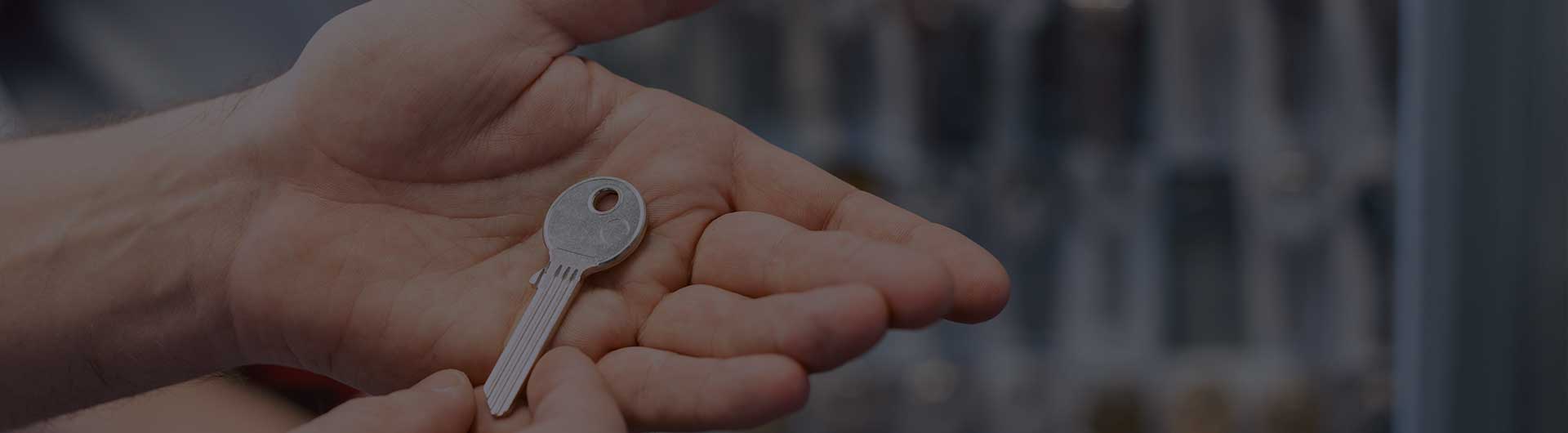 Locksmith showing key blanks in his shop.