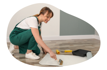 A paperhanging contractor applies adhesive to the back of wallpaper.