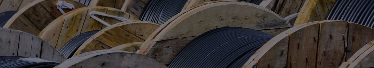 Wooden coils of electric cable in outdoor storage