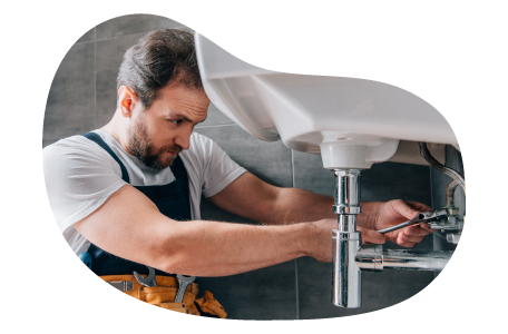 Plumber fixing the pipe under a sink. Plumber fixing the pipe under a sink.