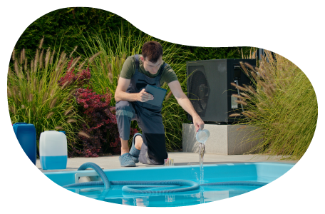 A pool and spa contractor adds chemicals to a new swimming pool. A pool and spa contractor adds chemicals to a new swimming pool.