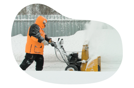 Snow removal professional plowing a sidewalk.