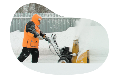 Snow removal professional plowing a sidewalk.