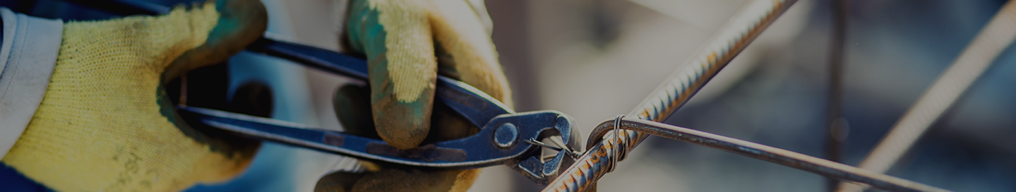 A steel erector contractor secures a length of rebar with wire.