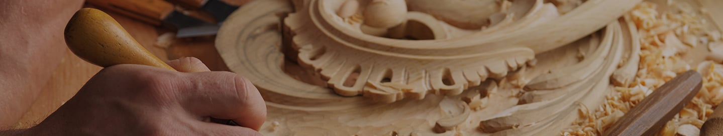 A contractor uses a lathe chisel to create an elaborate woodcarving. A contractor uses a lathe chisel to create an elaborate woodcarving.