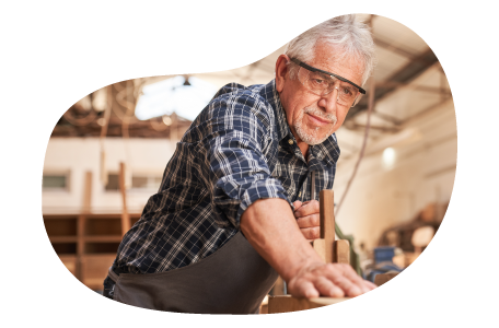 A woodworker smooths the surface of a piece of furniture.