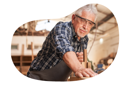A woodworker smooths the surface of a piece of furniture. A woodworker smooths the surface of a piece of furniture.