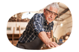 A woodworker smooths the surface of a piece of furniture.