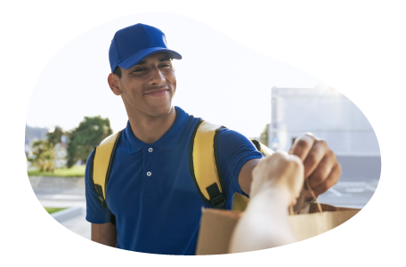 A Grubhub driver hands a meal to a customer. A Grubhub driver hands a meal to a customer.