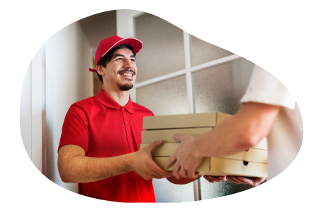 A delivery driver hands several boxes of pizza to a customer.