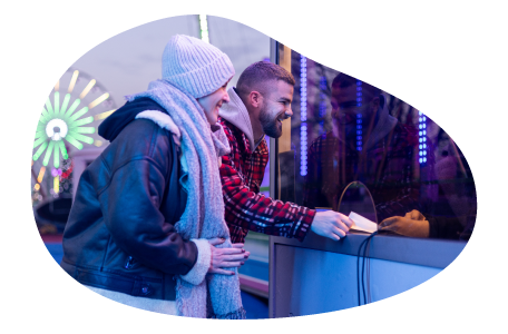 A couple buys tickets at an amusement park.