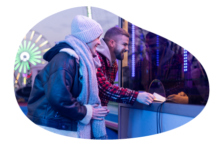 A couple buys tickets at an amusement park. A couple buys tickets at an amusement park.