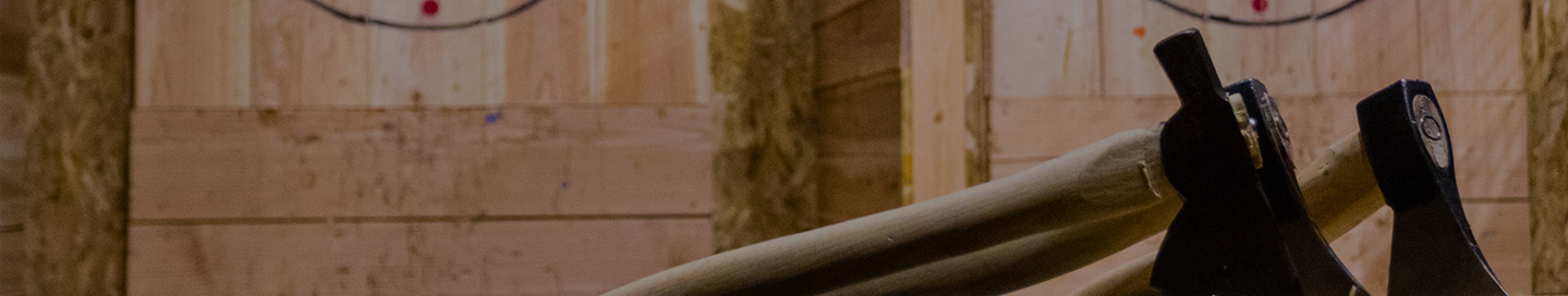 Axes embedded in a stump at an axe throwing business.