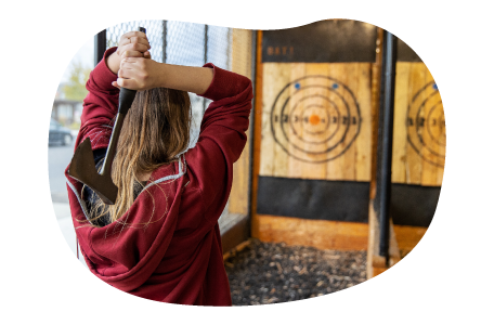 A customer at a hatchet house prepares to throw an axe.