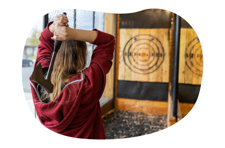 A customer at a hatchet house prepares to throw an axe. A customer at a hatchet house prepares to throw an axe.