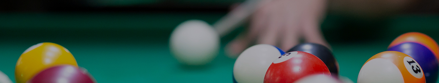 A player takes a shot in a billiard hall.