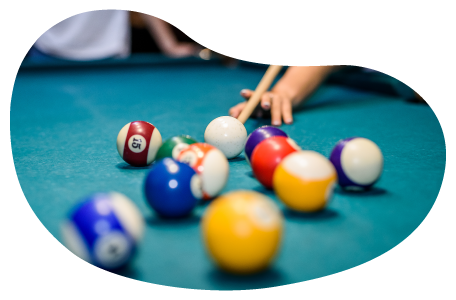 A player takes a shot in a billiard hall.