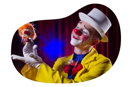 A clown in a yellow suit performs with a puppet. A clown in a yellow suit performs with a puppet.