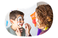 A face painter draws a clown face on a child.