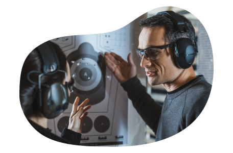 An employee helps a customer at a gun range calculate their score. An employee helps a customer at a gun range calculate their score.